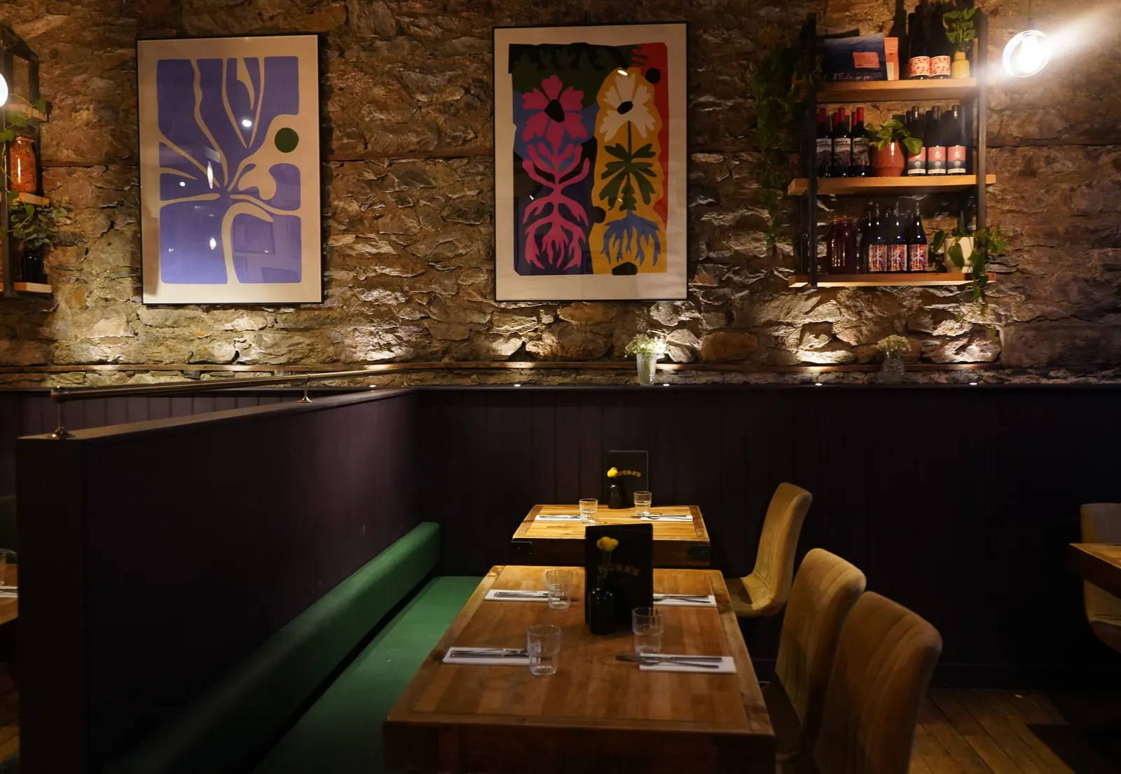 NORA'S dining room on North Hill, Plymouth, with stone walls, artwork and tables set for dinner